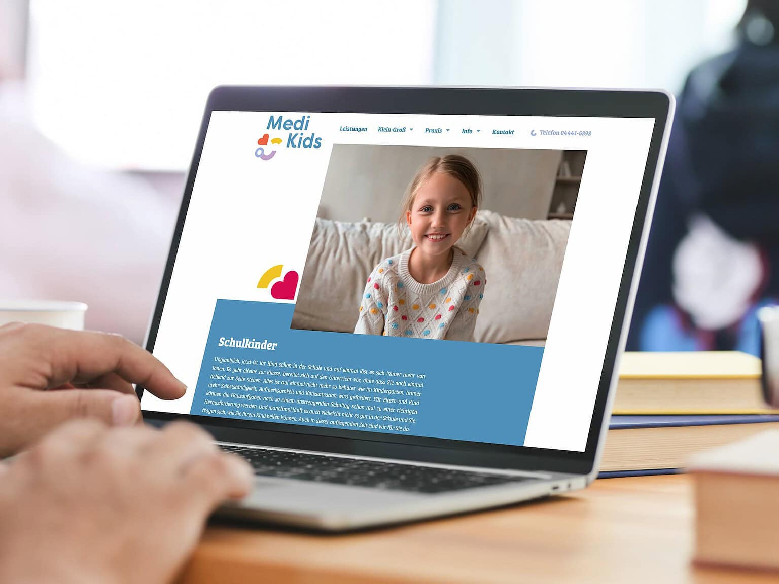Kinderarztpraxis Website mit freundlichem Kindergesicht auf Laptopbildschirm.